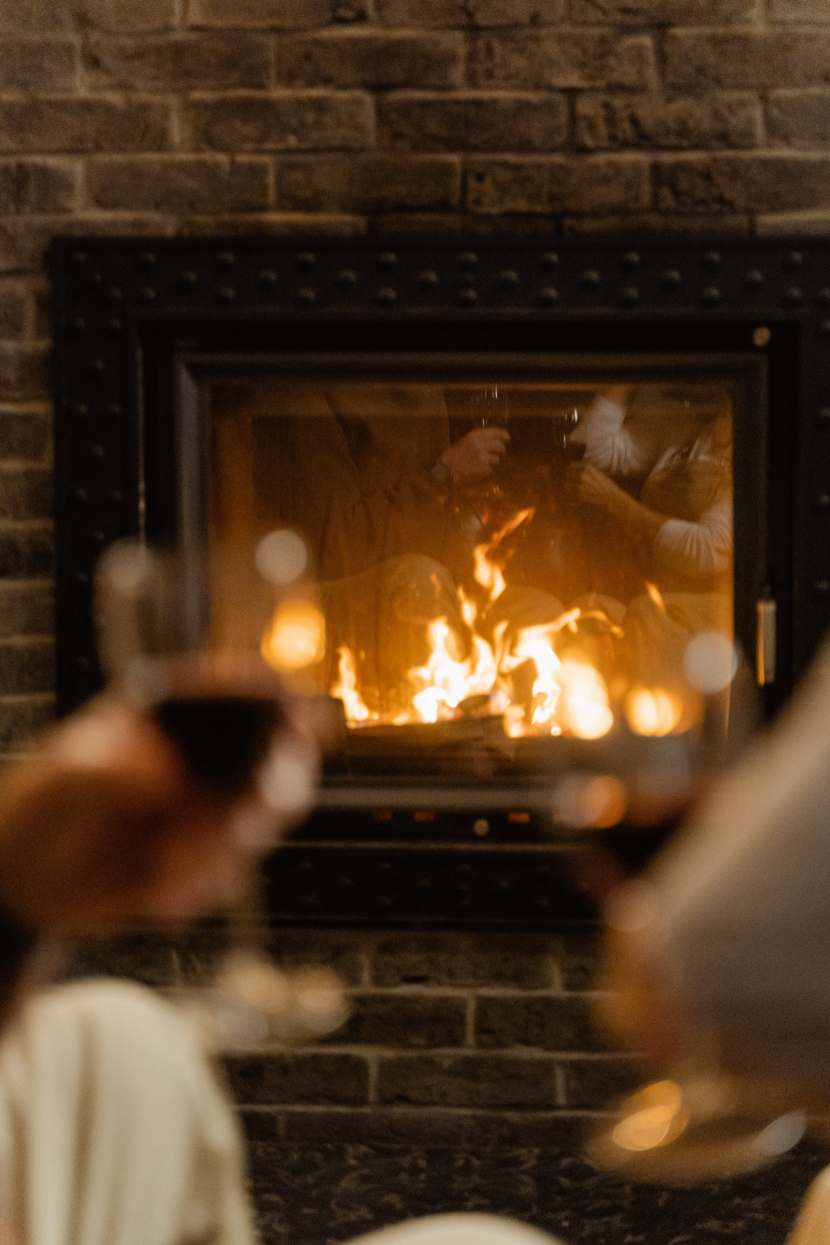 people drinking wine in front of fireplace