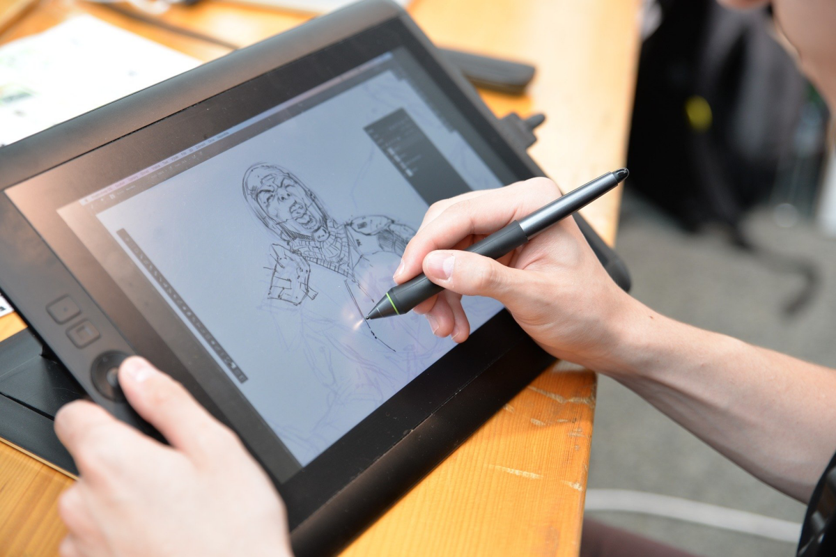 person drawing on digital art tablet