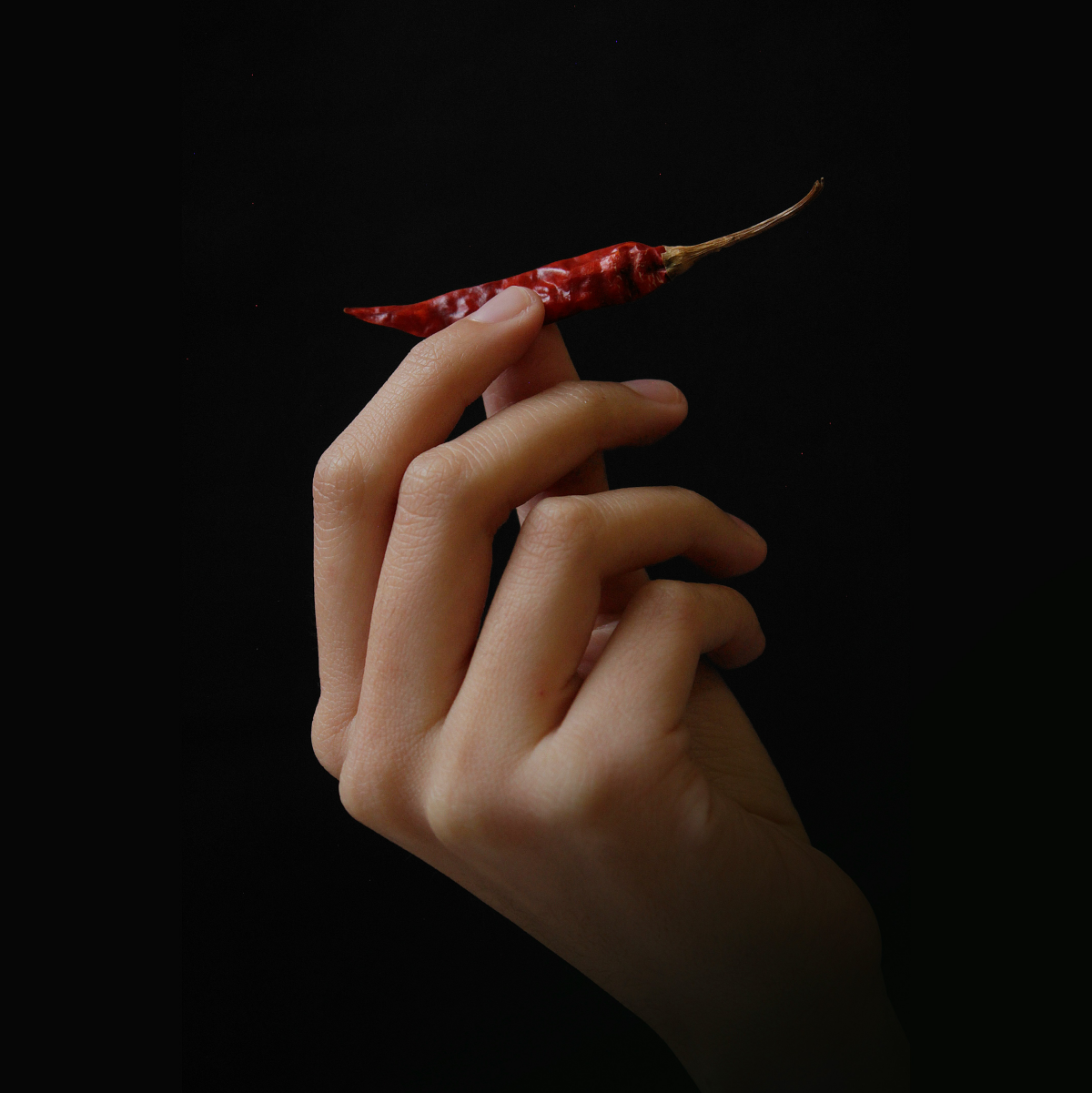 person holding a spicy pepper
