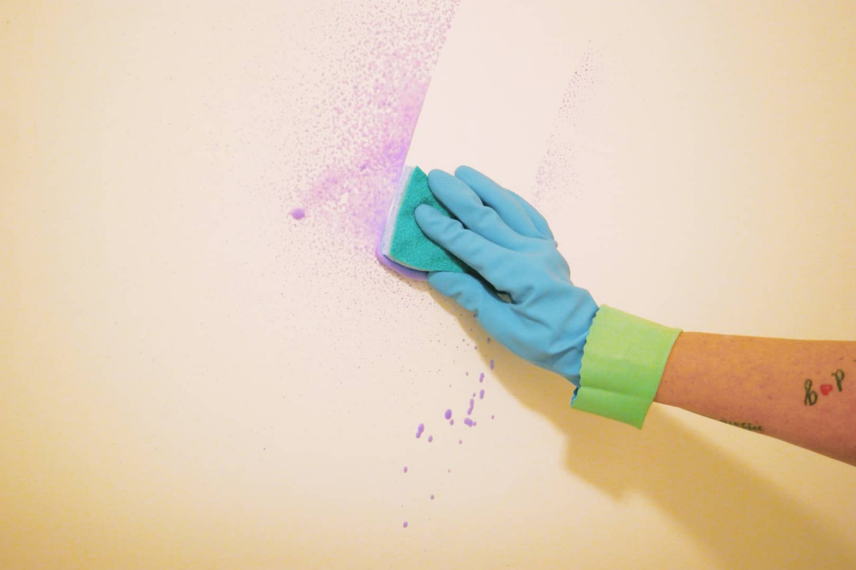 purple stain on wall being cleaned