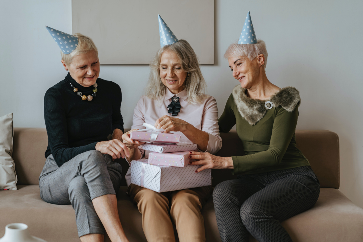 three old women sitting on a couch celebrating