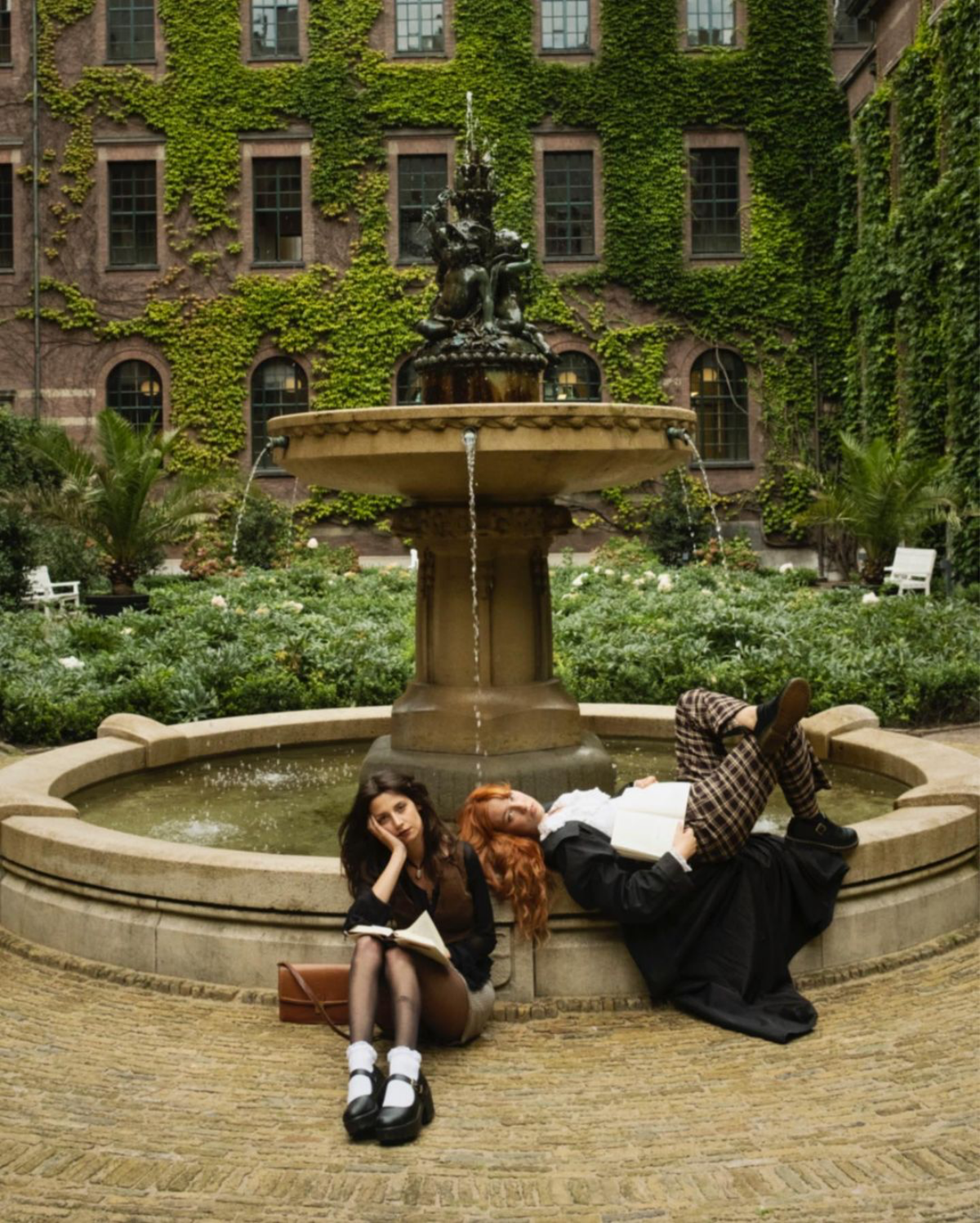two girls sitting by fountain