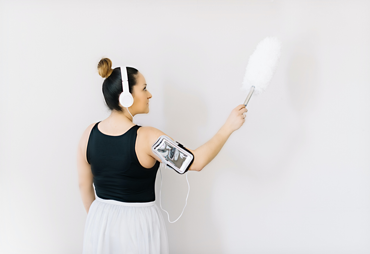 woman dusting while listening to music