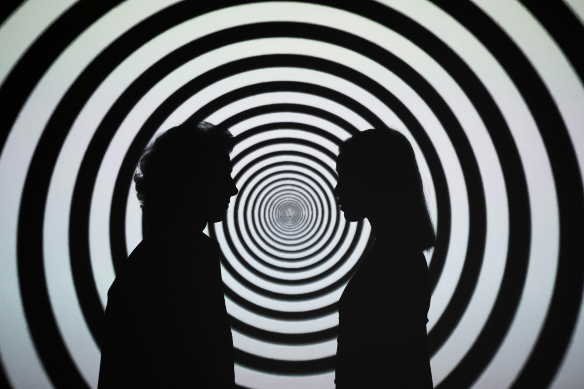 man and woman standing in hypnosis swirl