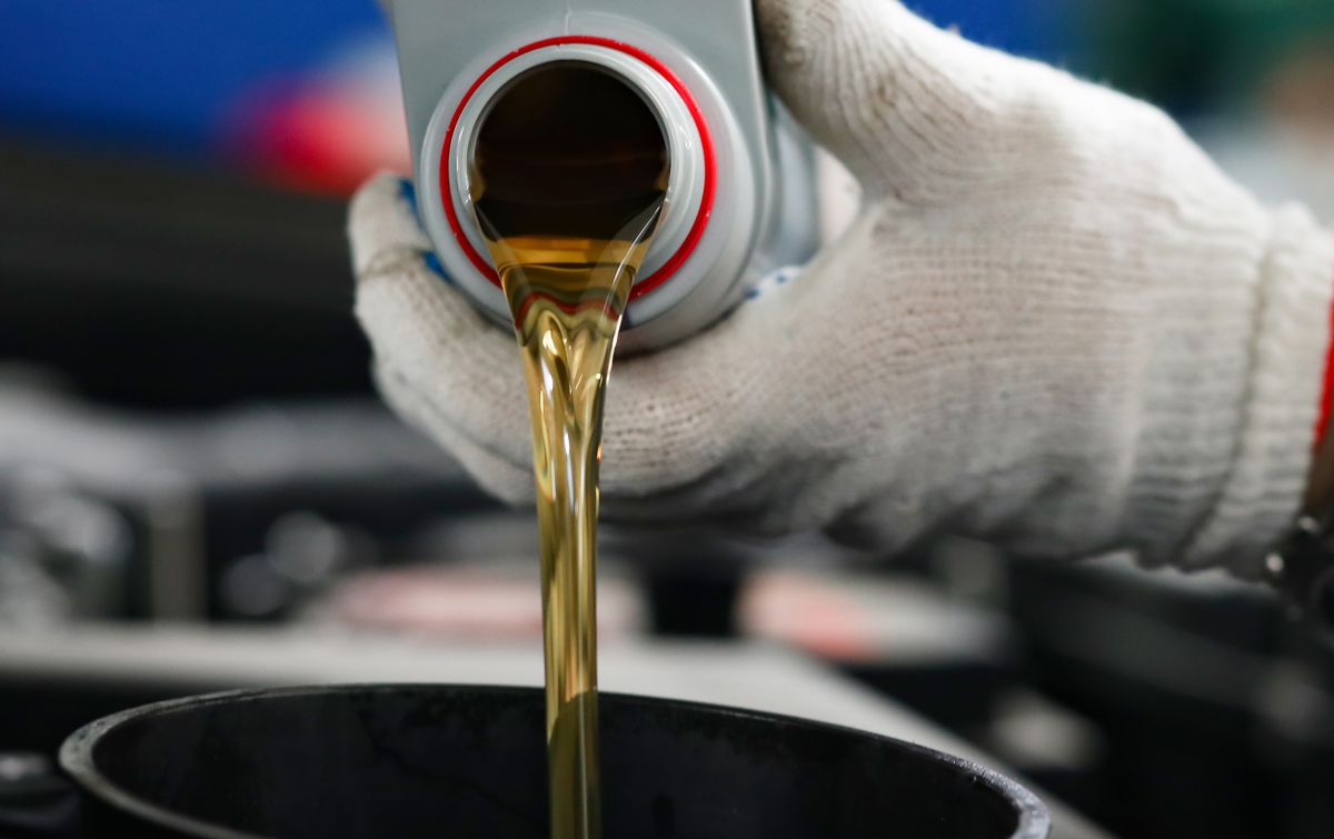 person pouring motor oil