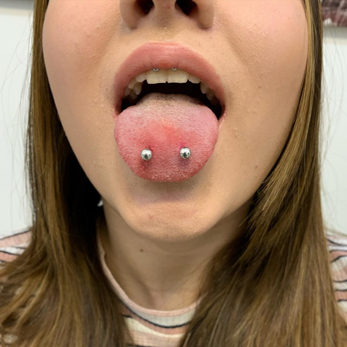 venom bites tongue piercing woman