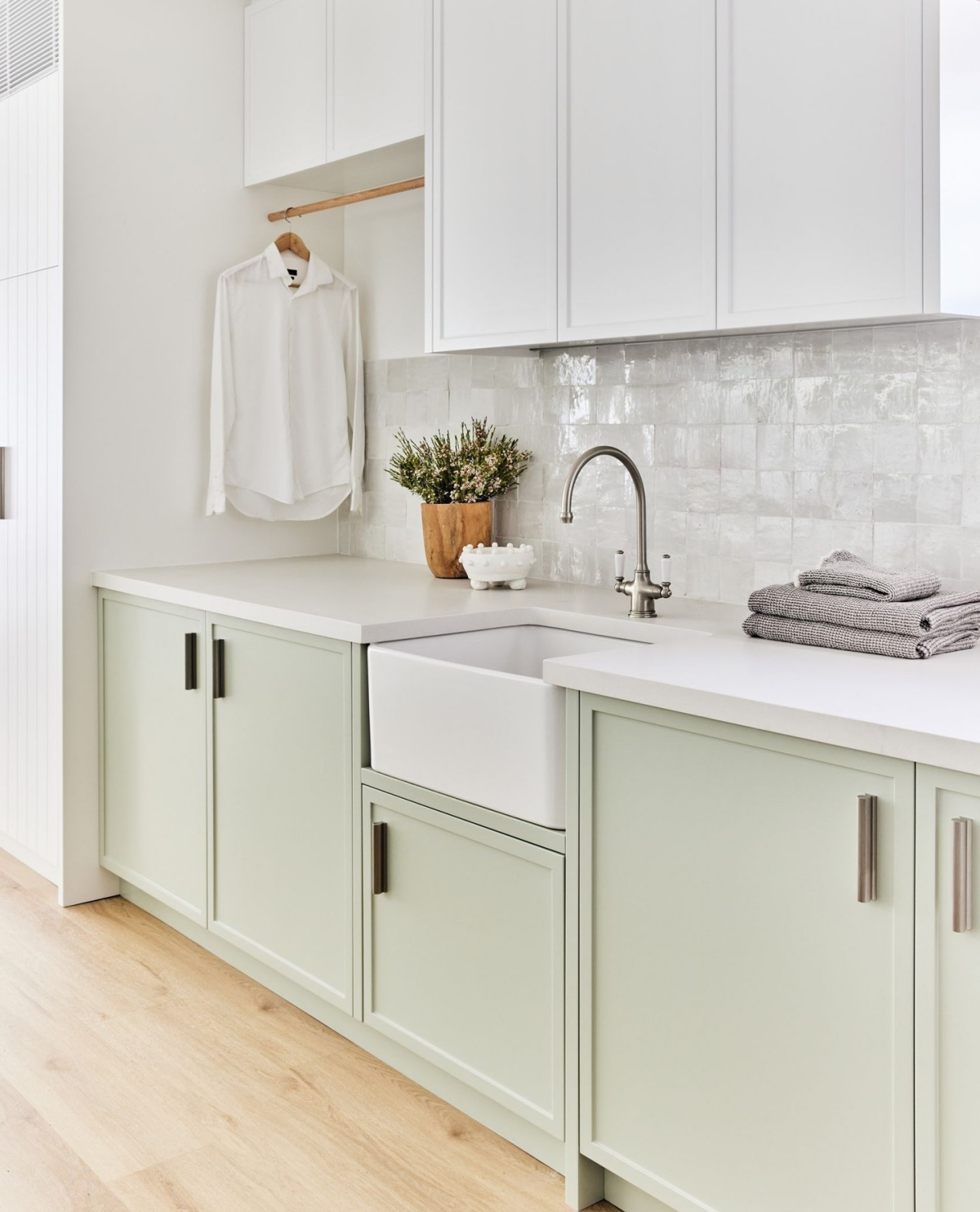 minty hue cabinetry in laundry room