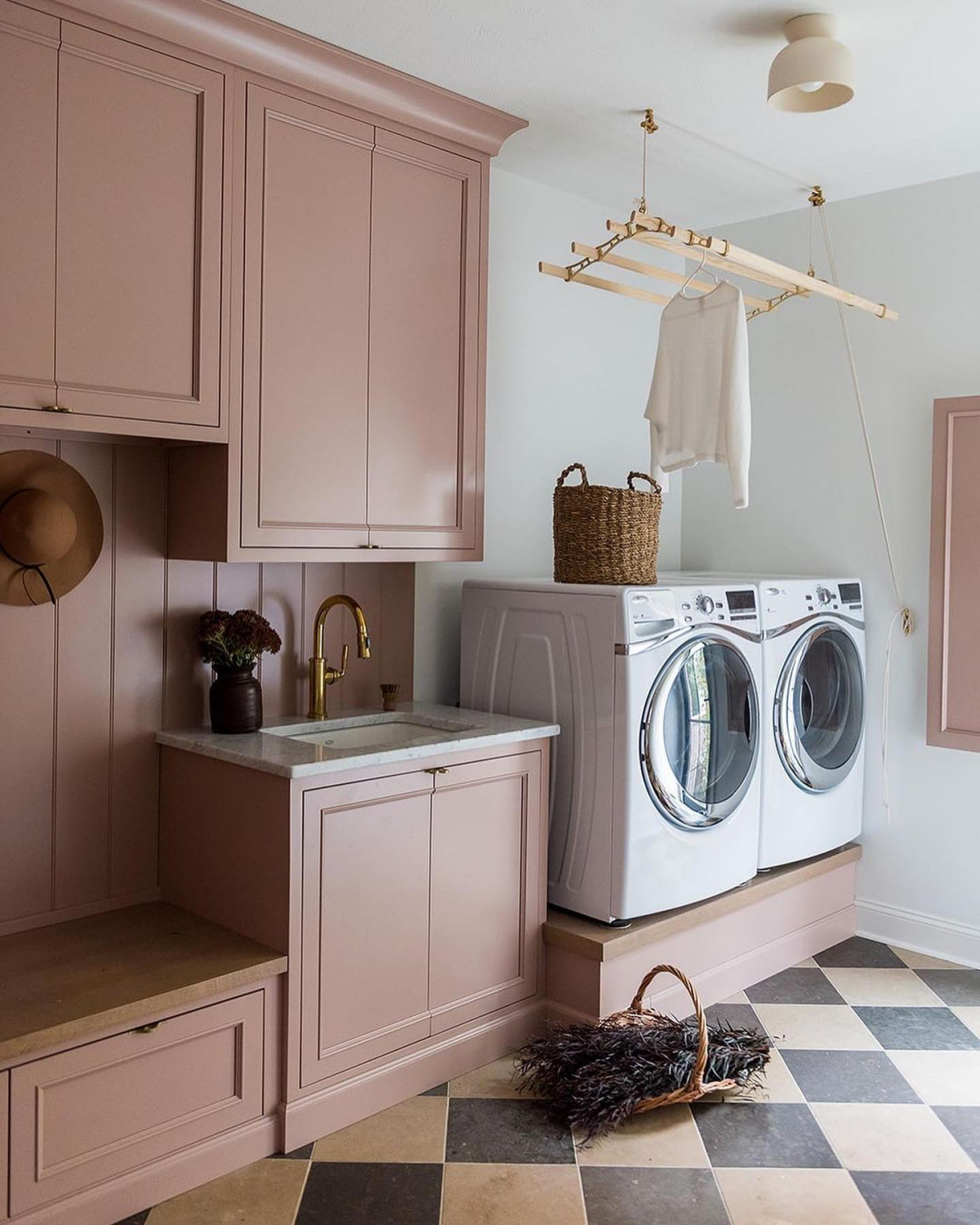 pink laundry room with elevated appliances