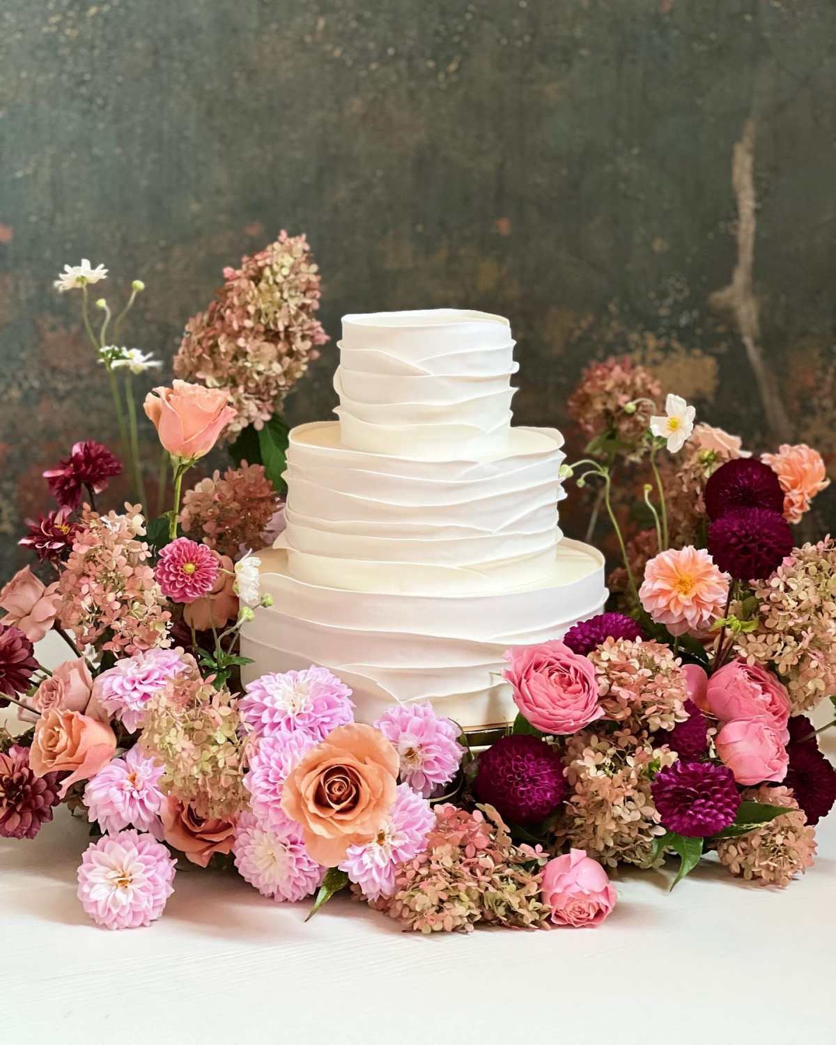 white three tier cake with flowers