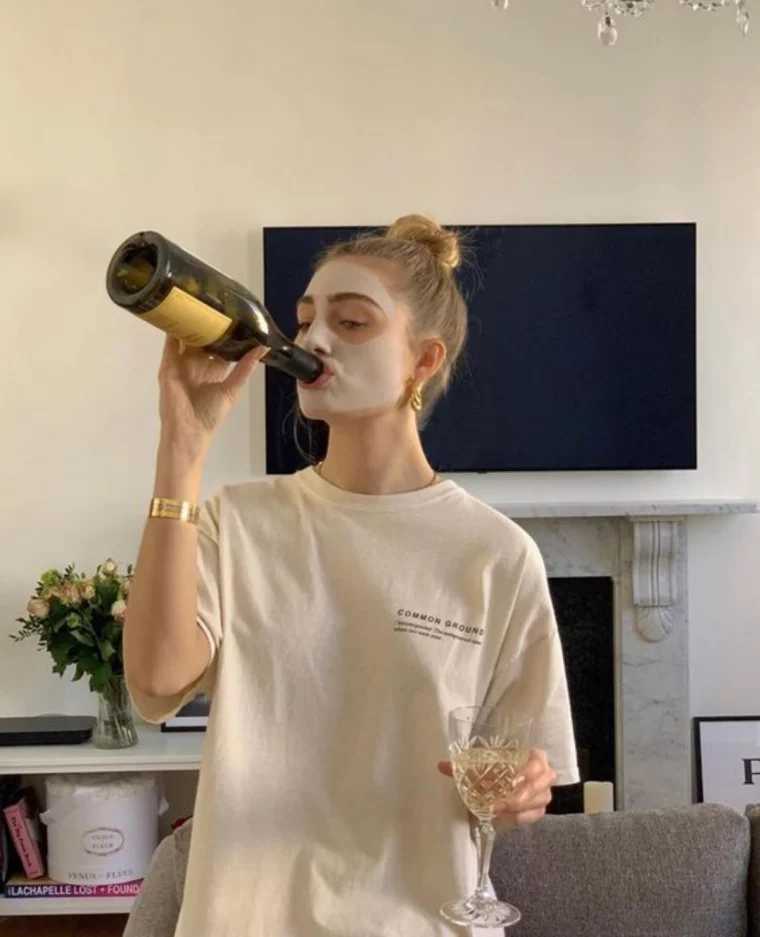 woman drinking wine with a mask on