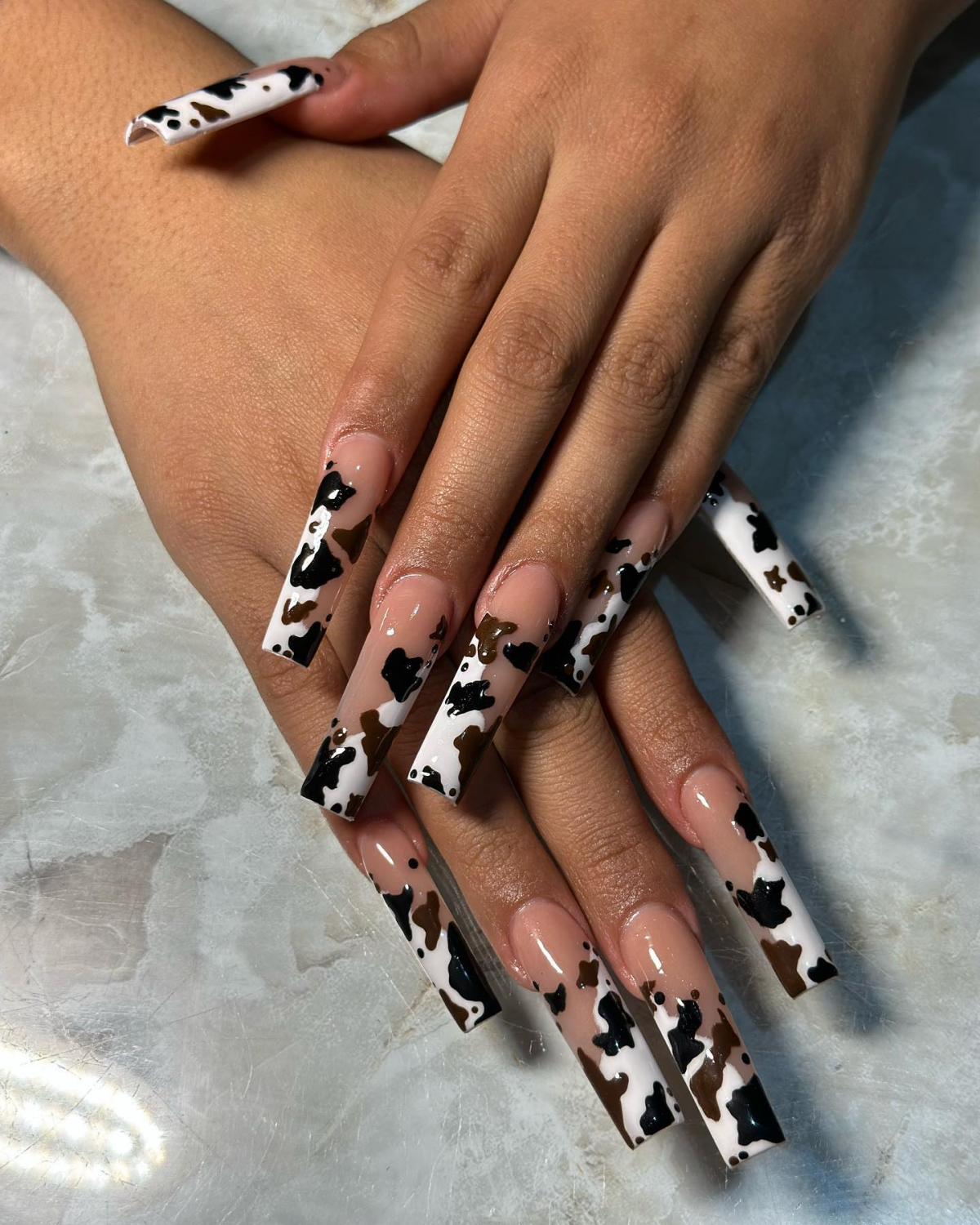 brown and black cow print with white and neutral nails