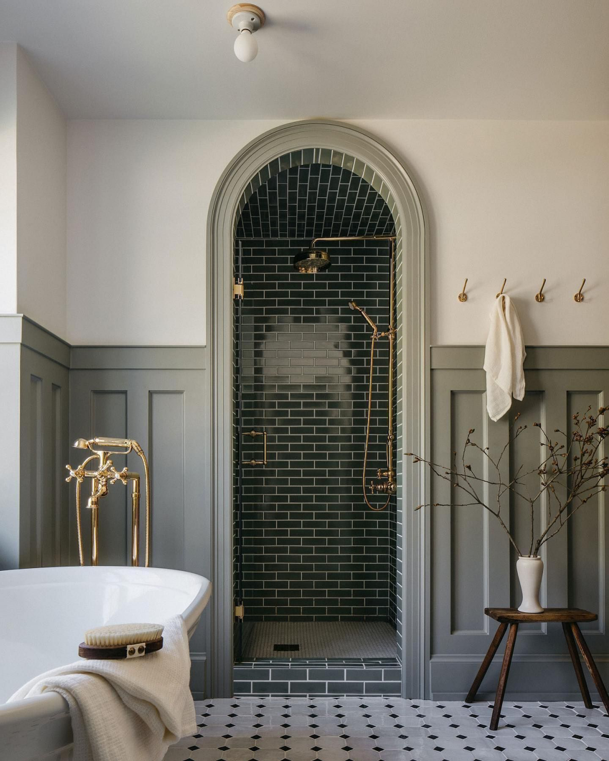 small arched shower with dark forest green tiles